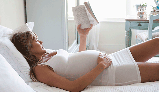 embarazada cama leyendo