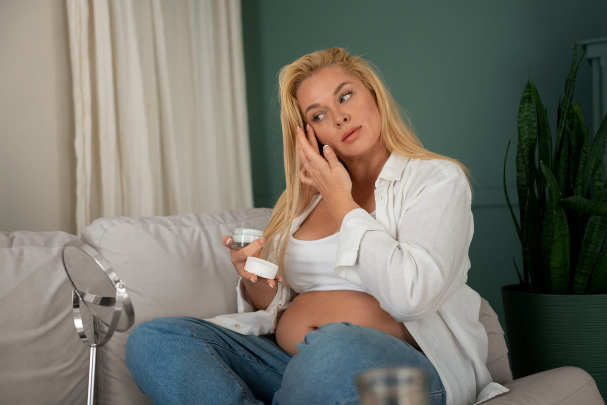 mujer embarazada colocándose cremas en la cara