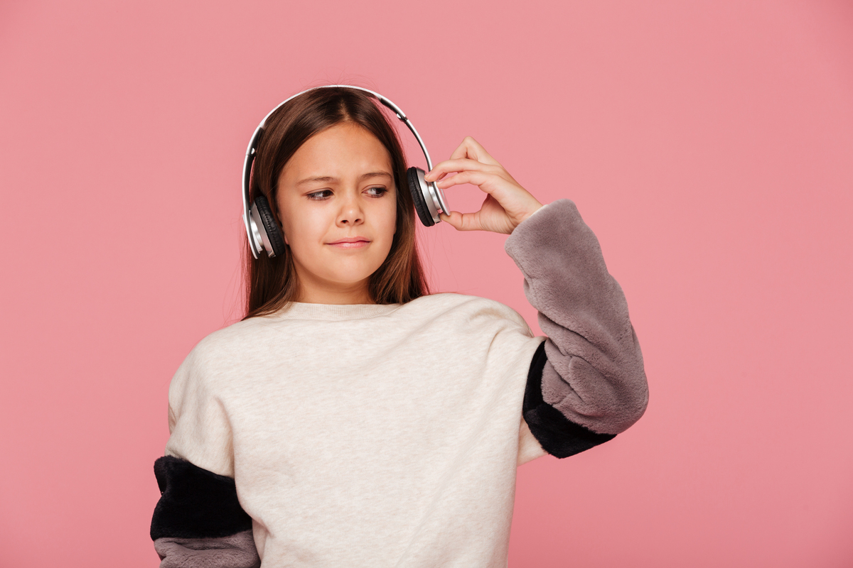 niña disgustada por el volumen de los audífonos