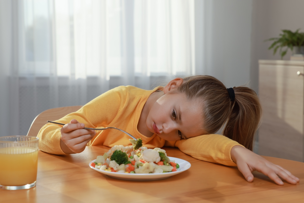 niña sin intención de comer plato de comida