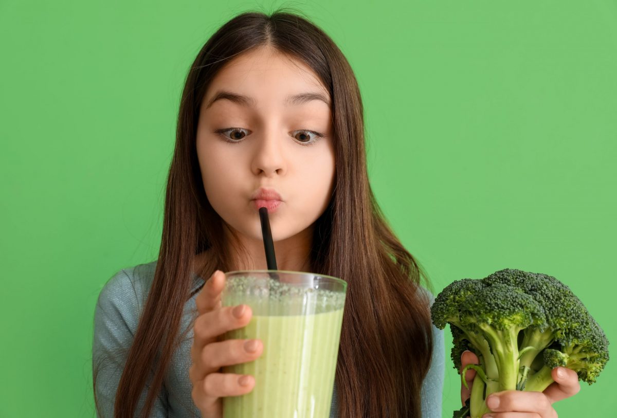 Little,Girl,With,Broccoli,Drinking,Smoothie,On,Green,Background