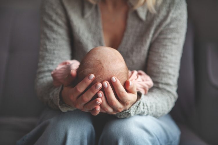 Close,Up,Mom,Gently,Cradling,And,Rocking,Newborn,Baby,In Close,Up,Mom,Gently,Cradling,And,Rocking,Newborn,Baby,In