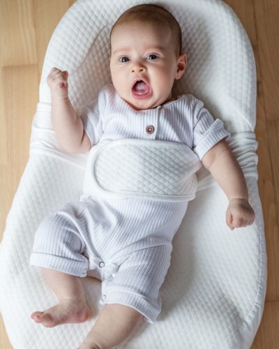 A,Two-month-old,Baby,Rests,In,A,Soft,White,Ergonomic,Cocoon.