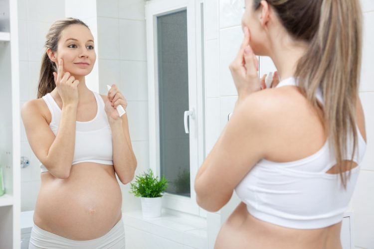 Pregnant,Woman,In,Looking,Into,Bathroom,Mirror